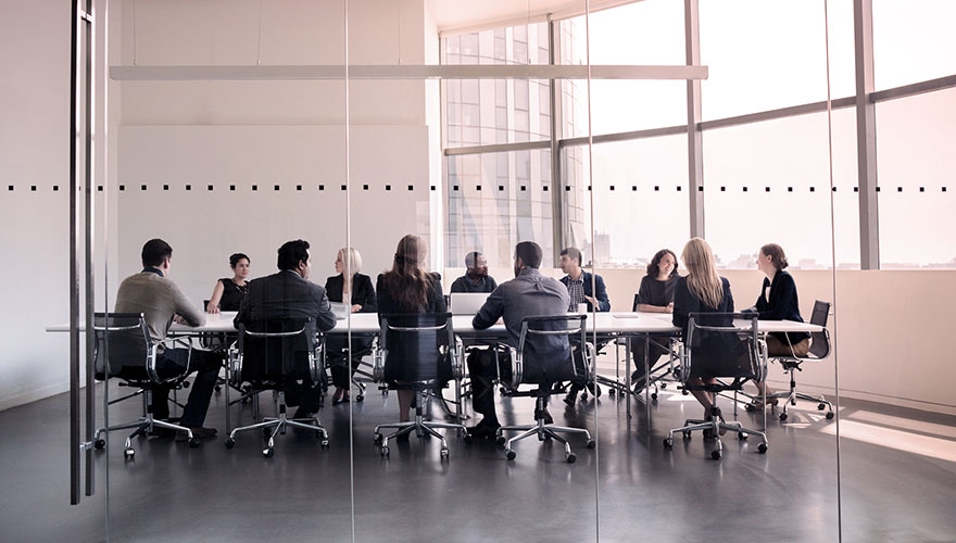 Photo of people sat round boardroom