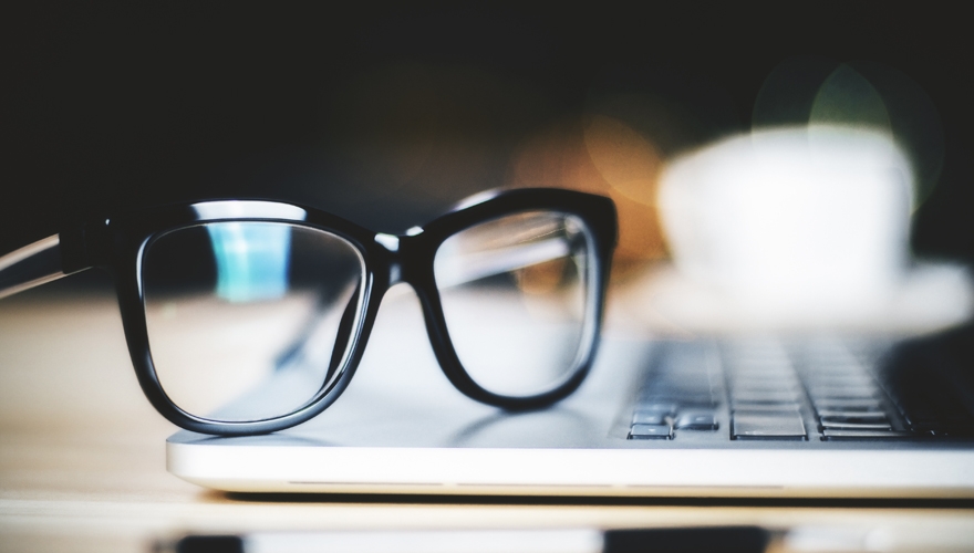 eyeglasses laying on top on laptop