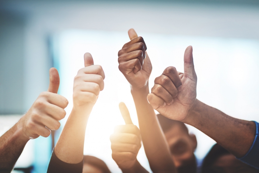 A diverse team doing collective thumbs up