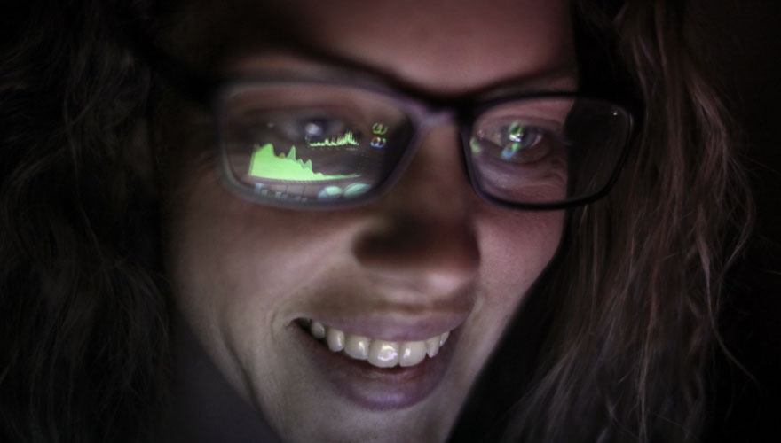Lady in glasses looking at a screen reflected in her glasses image
